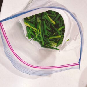 キッチンペーパーの間に小ネギを入れる